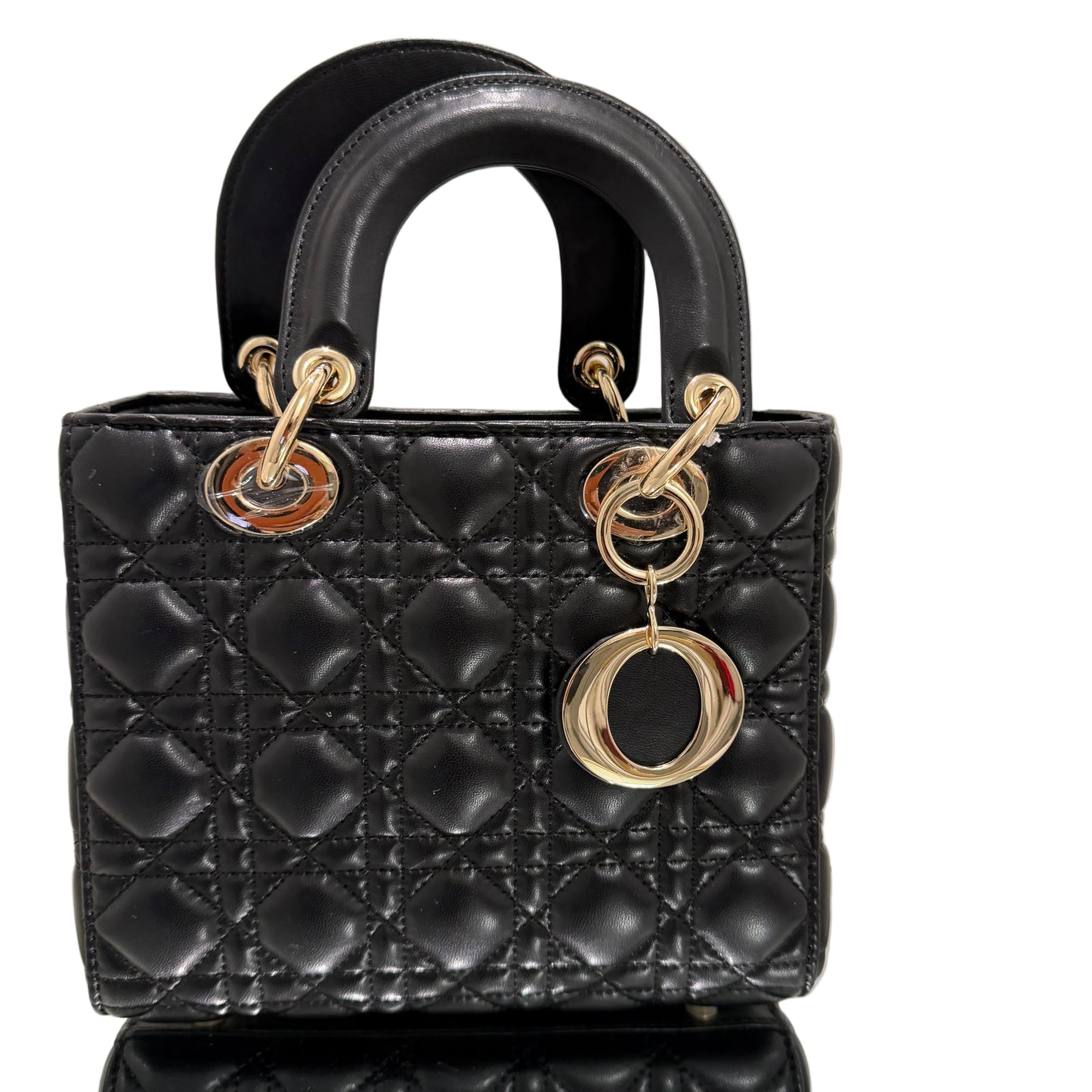Black quilted handbag with gold hardware on a neutral background