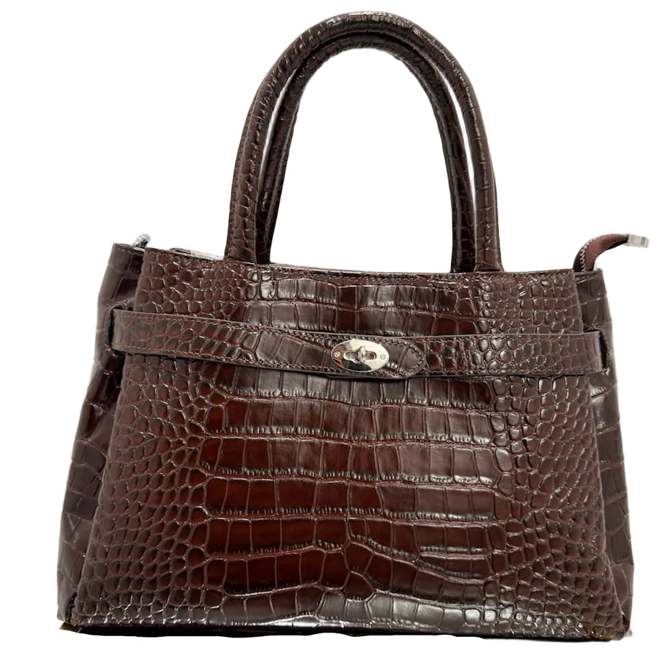 Brown crocodile-patterned handbag on a reflective surface with a light background