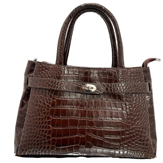 Brown crocodile-patterned handbag on a reflective surface with a light background