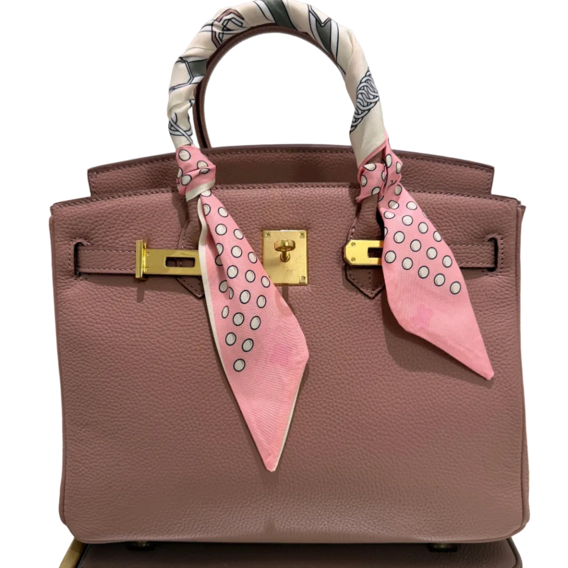 Brown handbag with pink accents and decorative elements on a light gray background