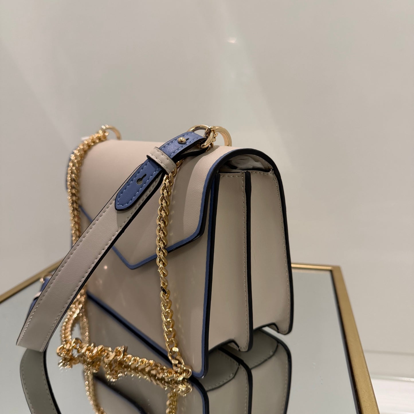 Handbag with gold chain strap on a white background