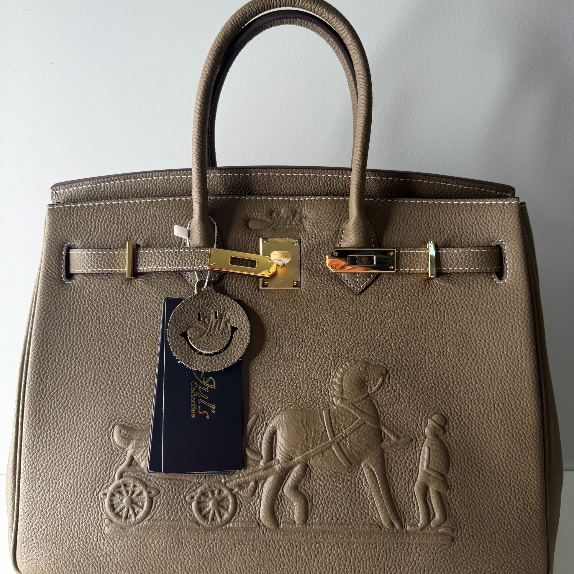 Brown leather handbag with gold hardware on a light gray background
