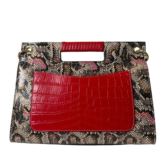 Designer handbag with snake print and red crocodile texture on a light gray background