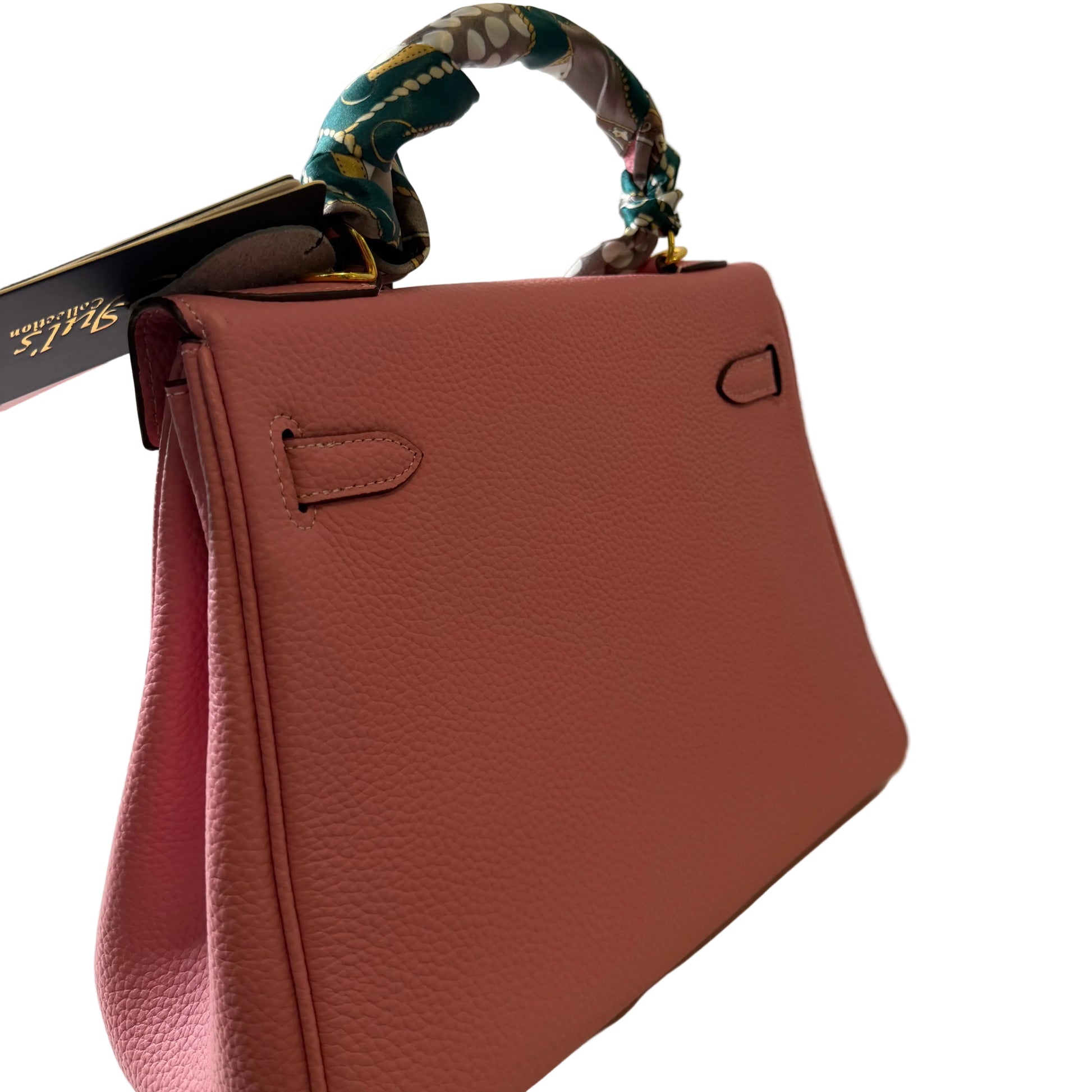 Pink handbag with a floral strap on a white background