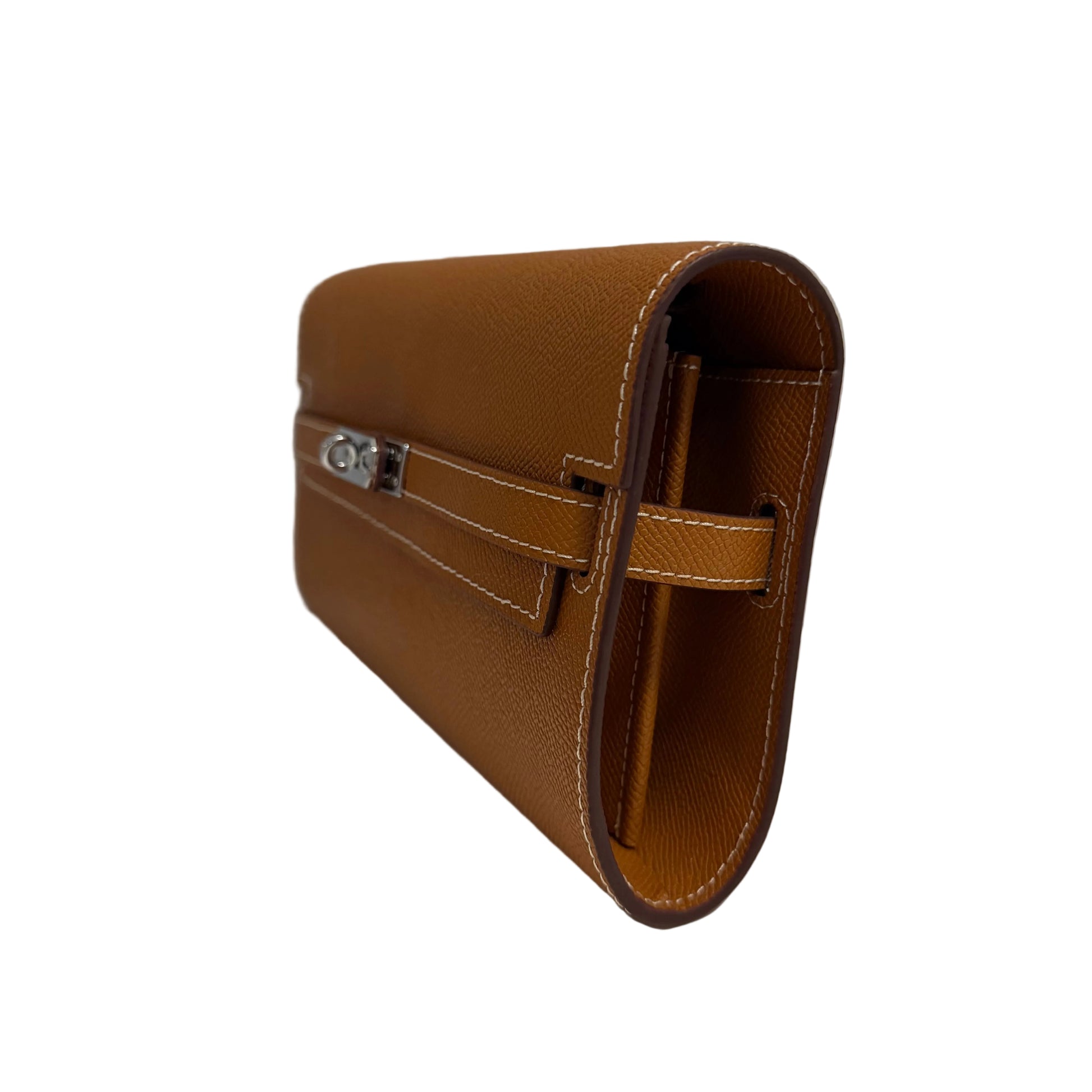 Brown leather clutch bag on a light surface with a neutral background