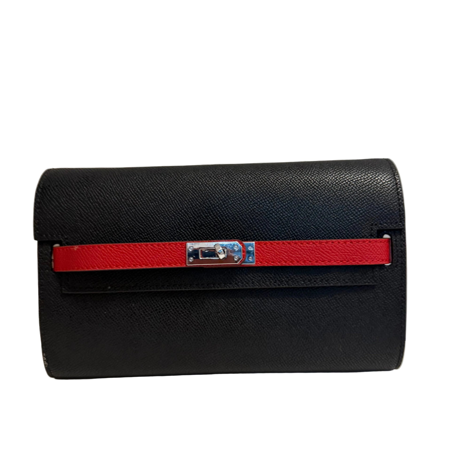 Black handbag with a red strap on a light gray background