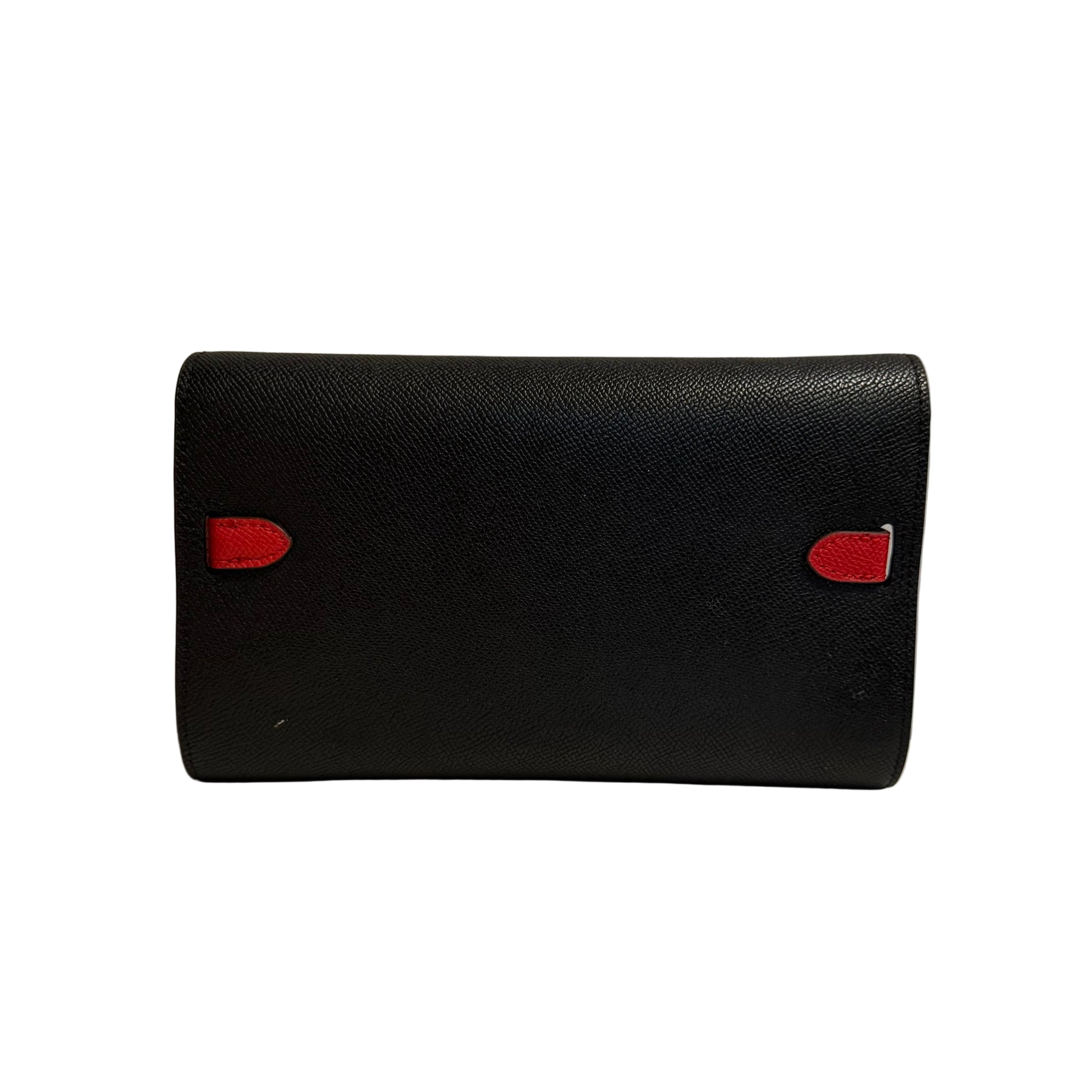Black leather wallet with red accents on a white surface against a gray background