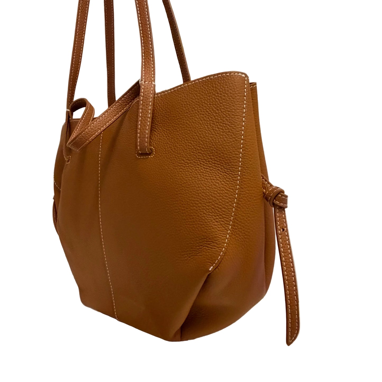 Brown leather handbag on a reflective surface with a neutral background