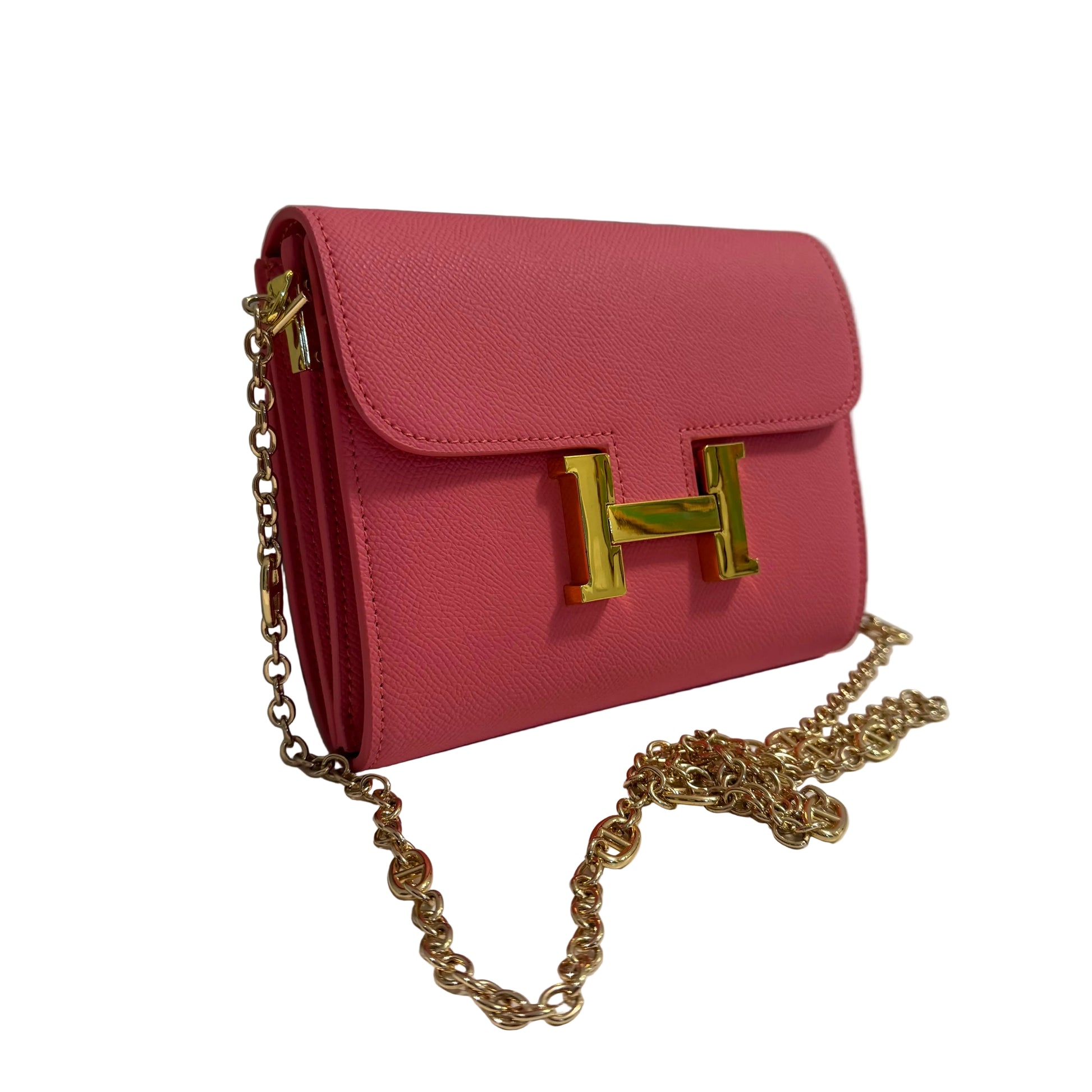 Pink handbag with gold chain and clasp on a white surface