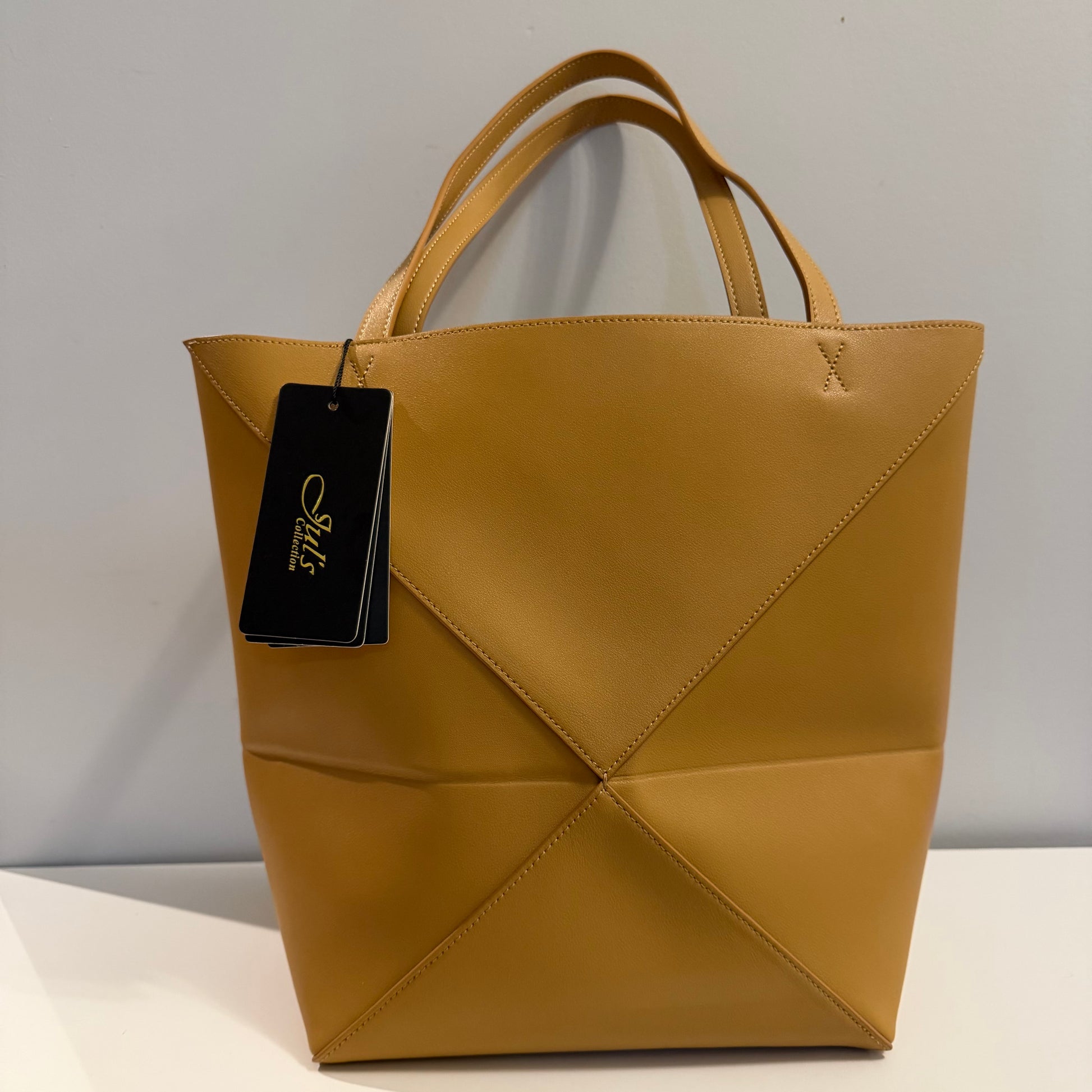 Brown handbag with a tag on a gray background