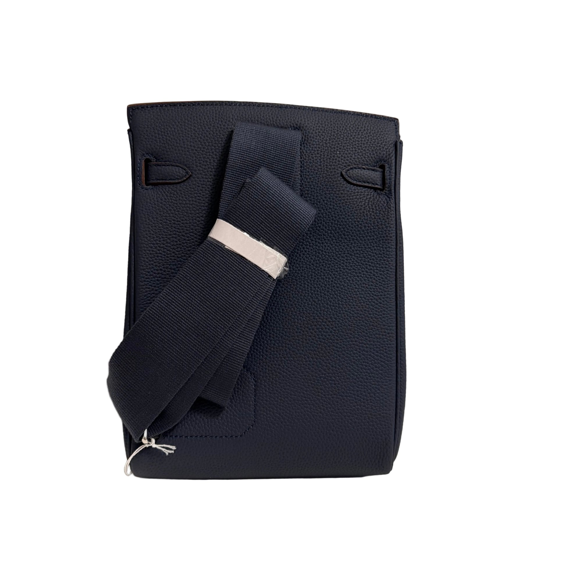 Navy blue leather bag with a strap on a light gray background