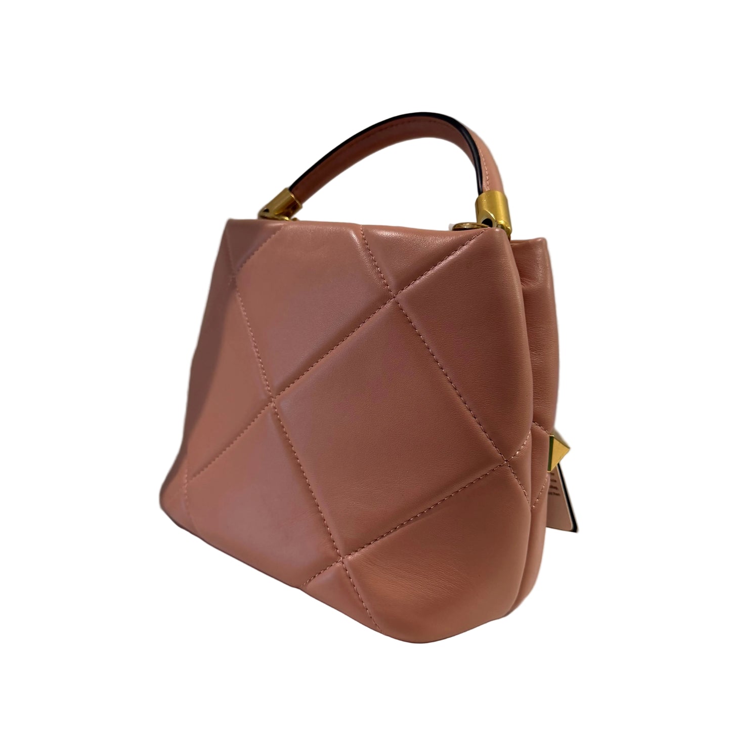 Brown quilted handbag on a white surface with a gray background