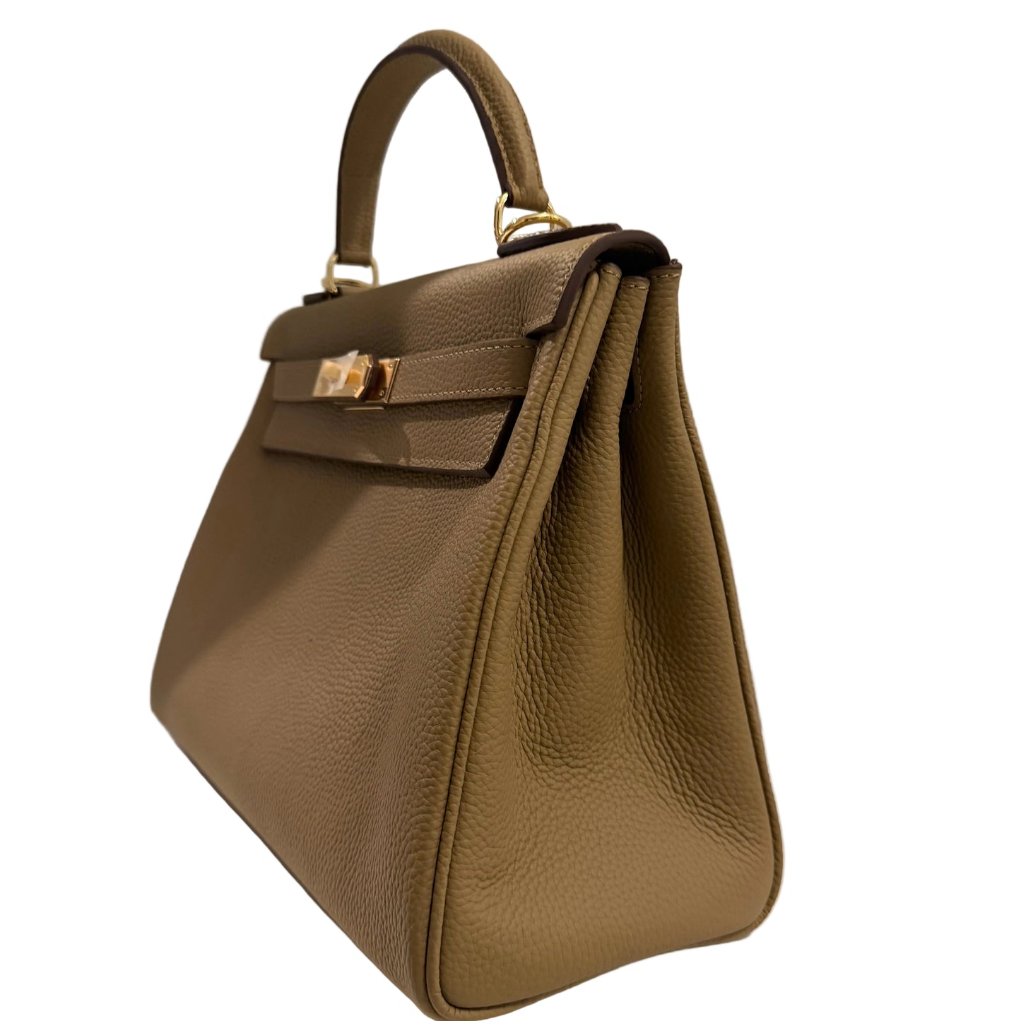 Brown leather handbag with gold hardware on a light gray background