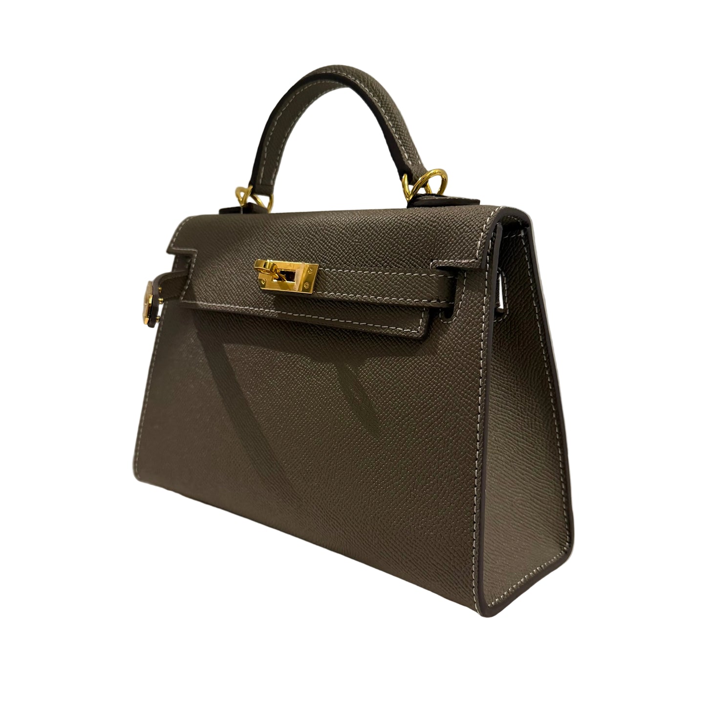 Brown handbag with gold hardware on a light surface and gray background