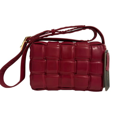 Red woven handbag with a strap on a neutral background