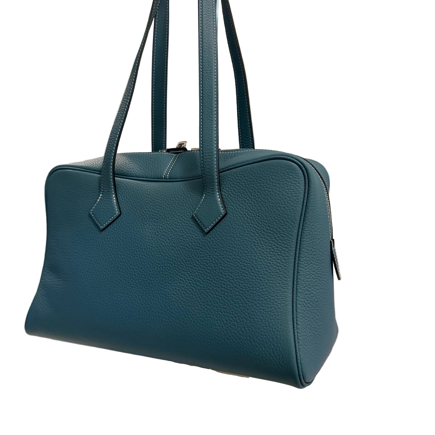 Blue handbag on a white stand with a neutral background