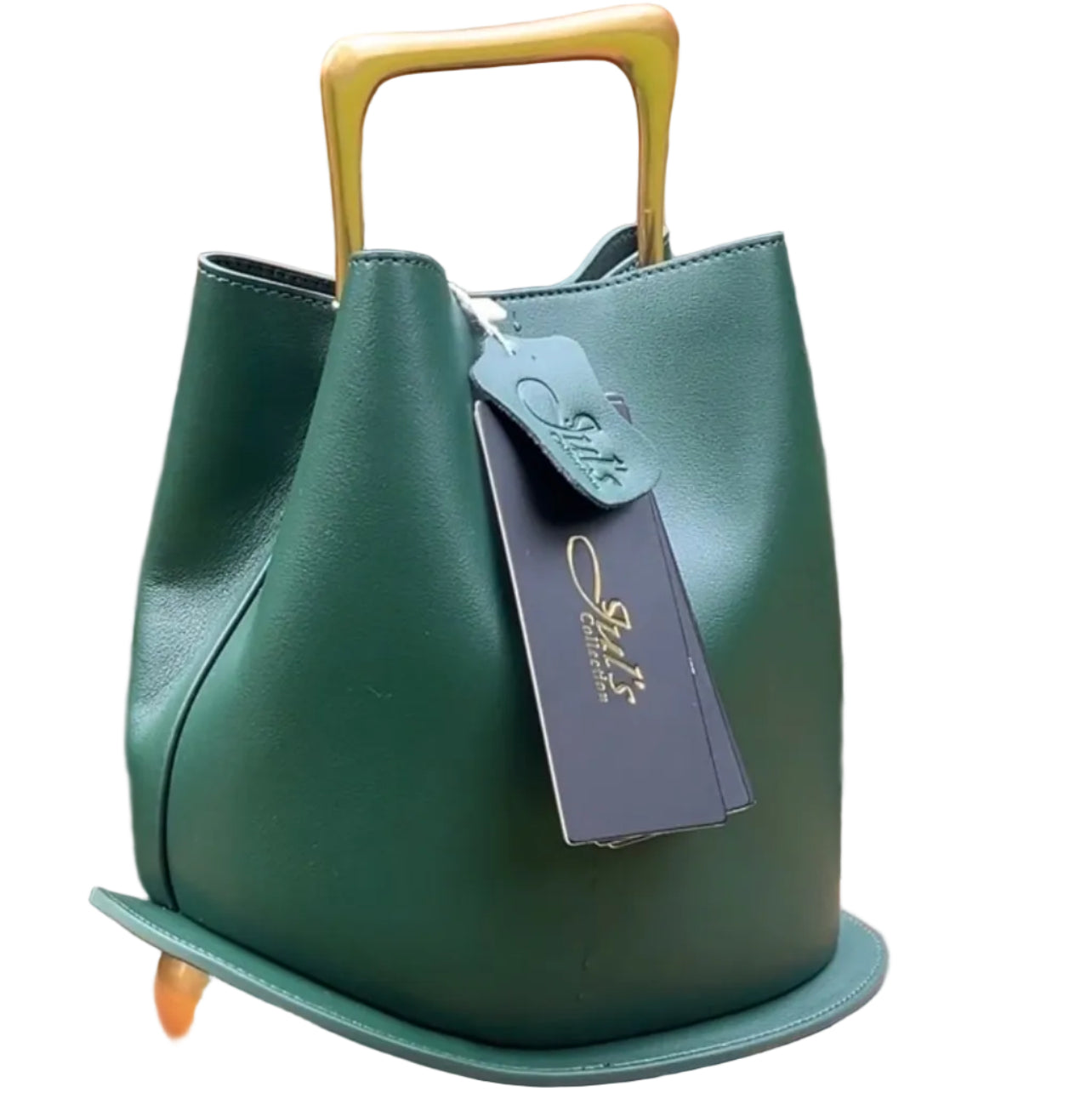 Green handbag with a yellow handle on a brick ledge, with a statue and trees in the background.
