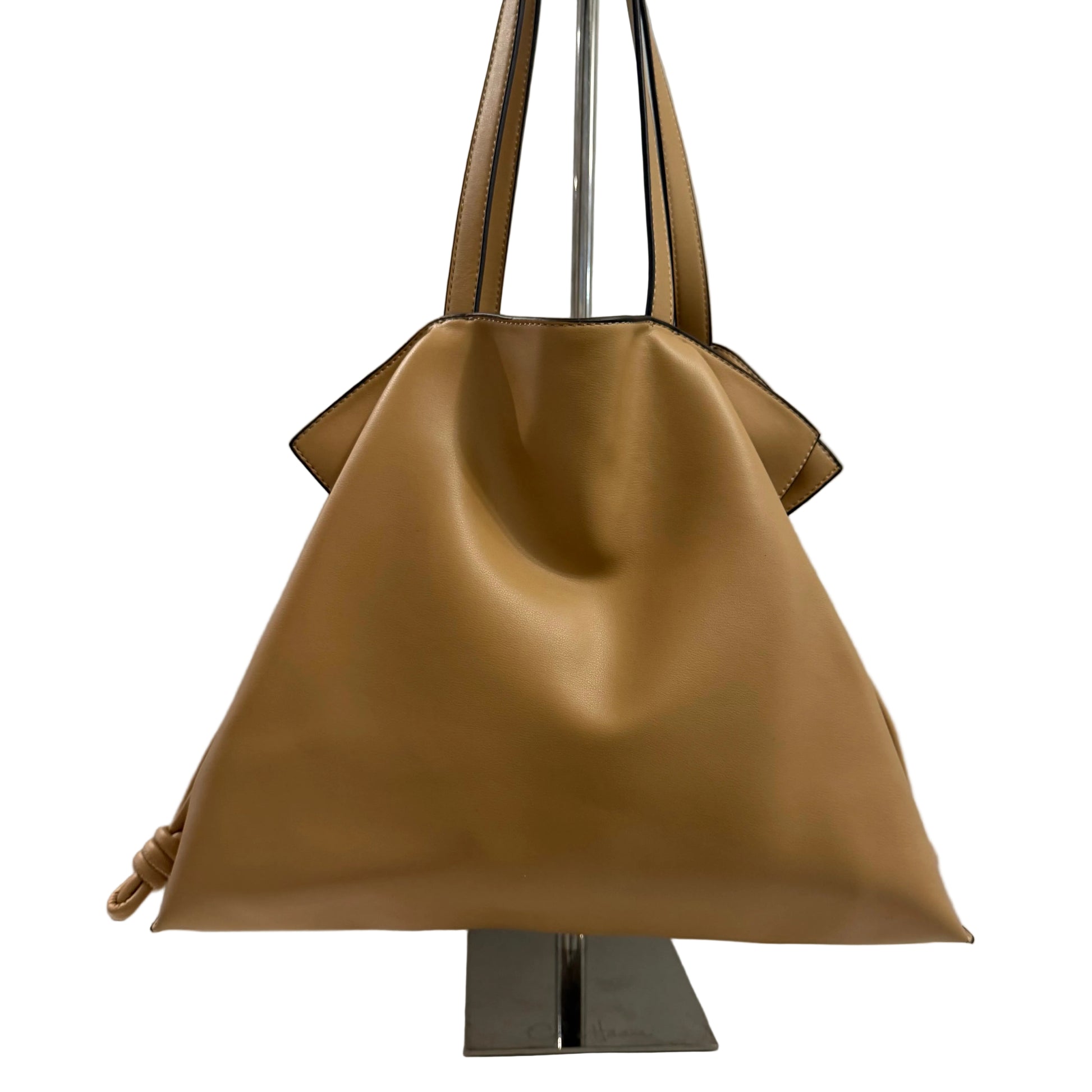 Brown handbag on a stand against a gray background