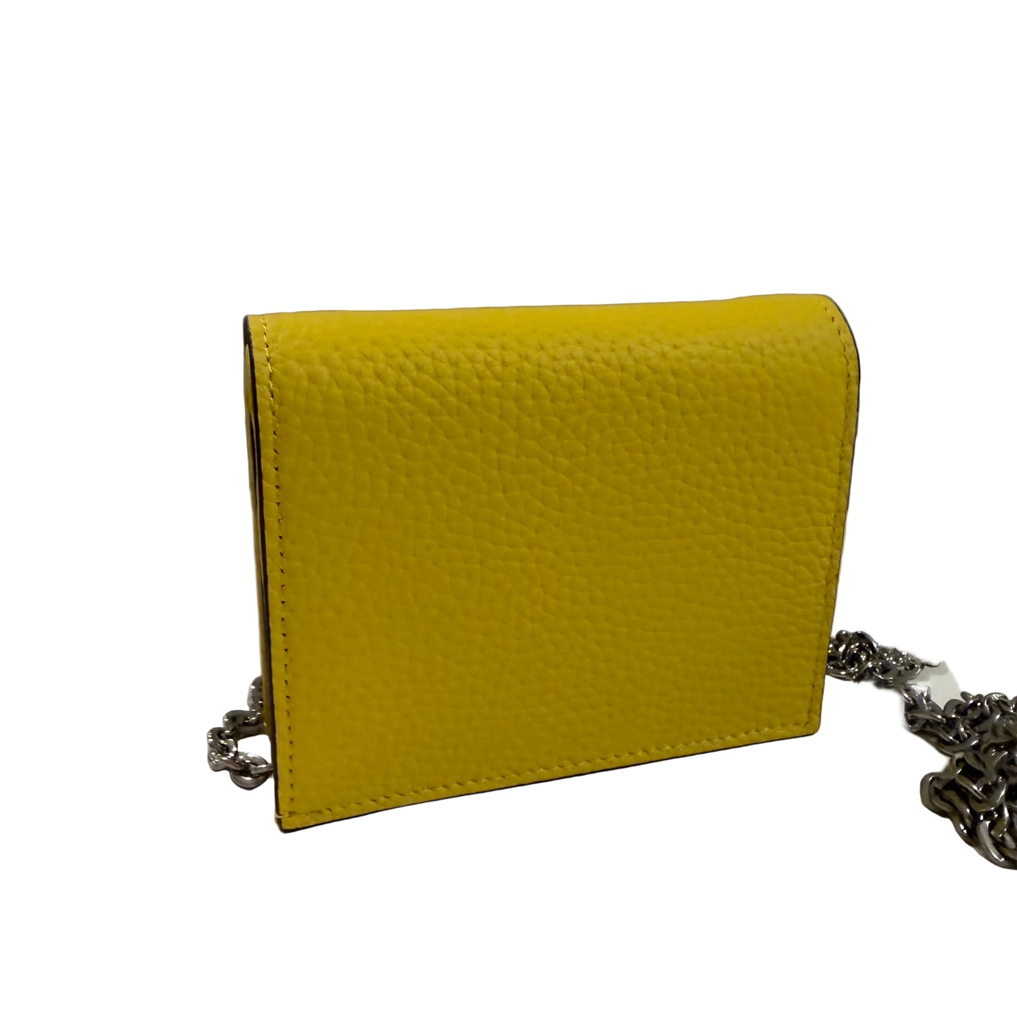 Yellow textured handbag with a chain detail on a white surface and gray background