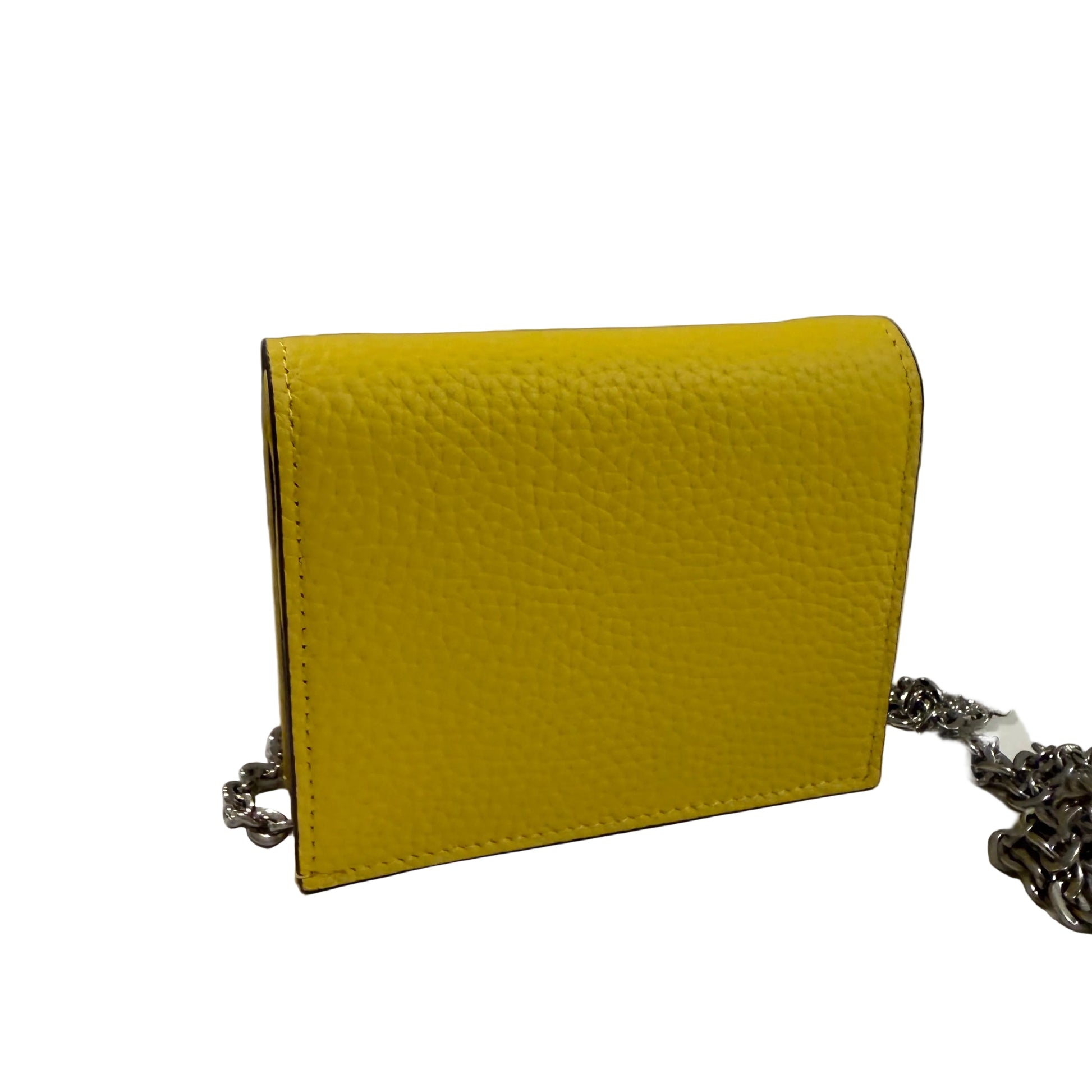 Yellow textured handbag with a chain detail on a white surface and gray background