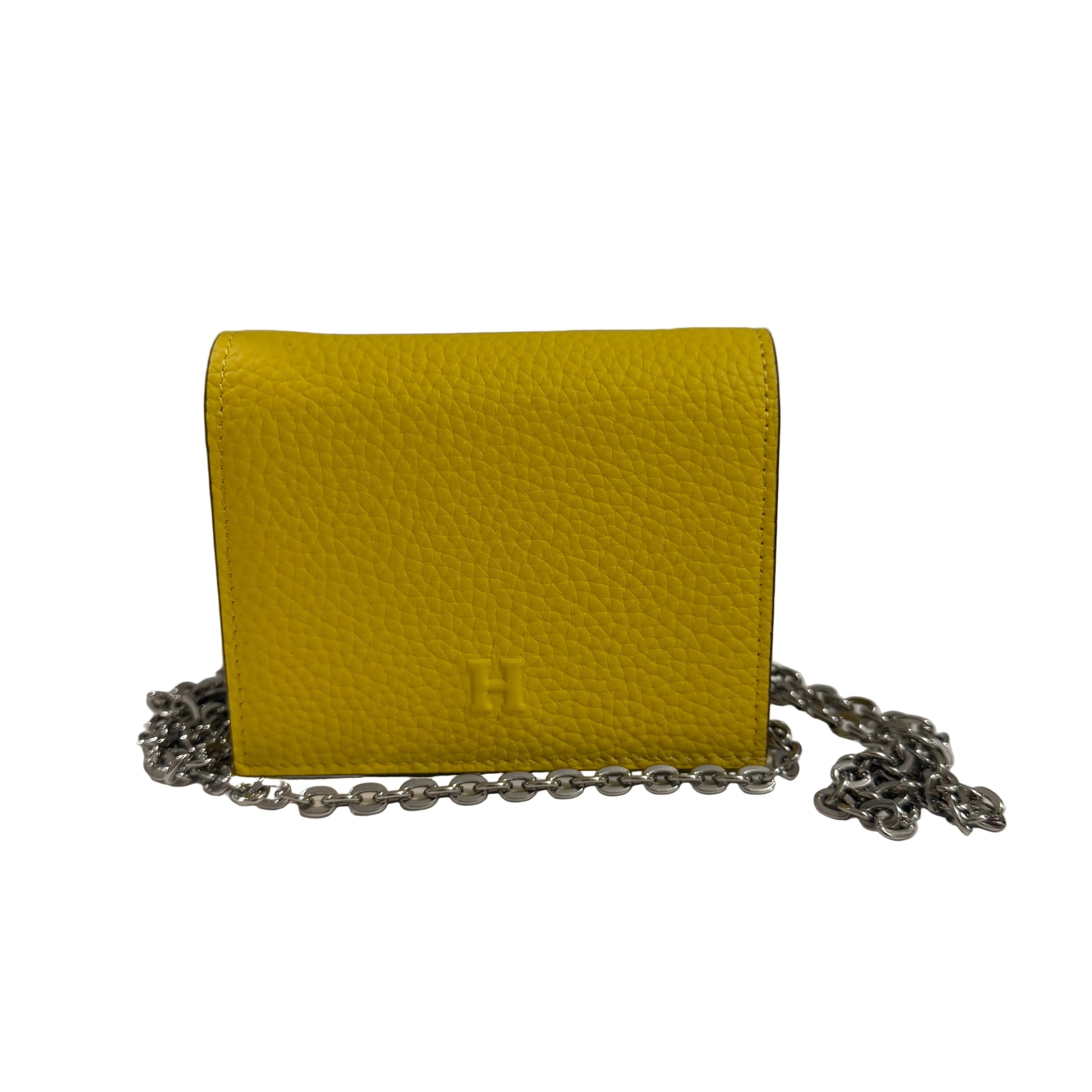 Yellow leather wallet with a chain on a white surface and gray background