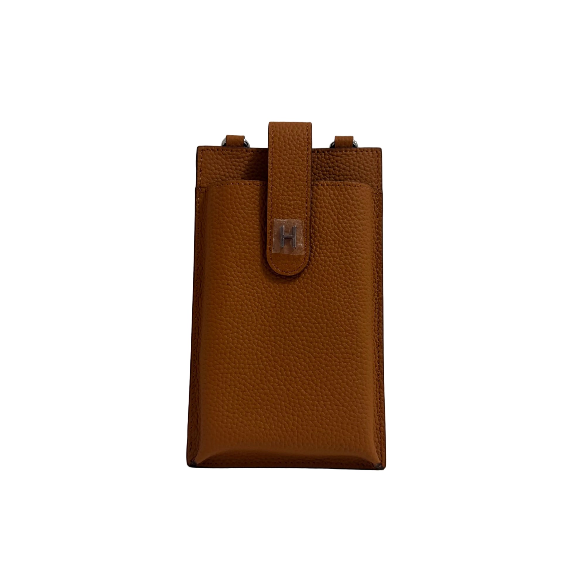 Brown leather pouch on a white surface with a gray background