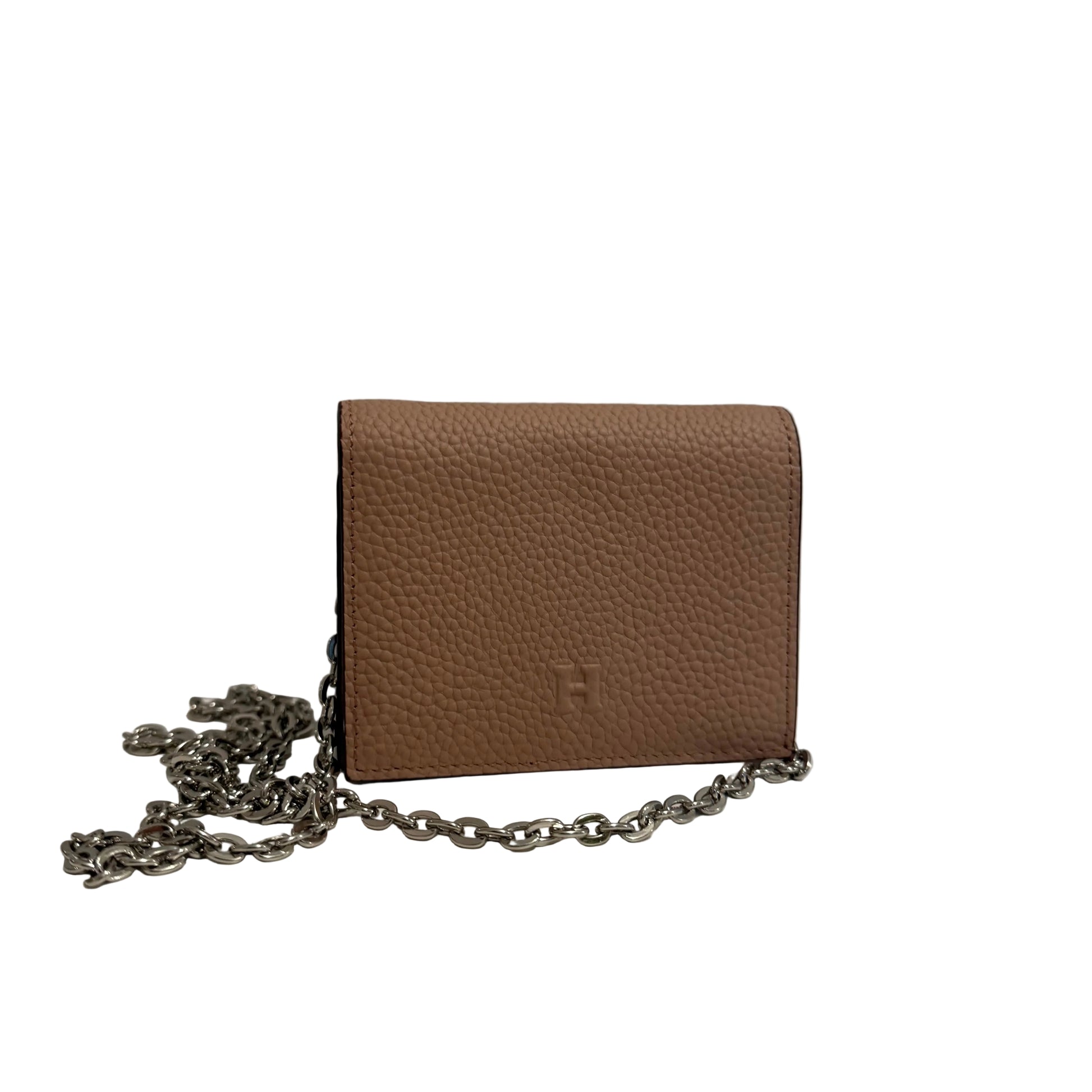 Brown leather handbag with a chain strap on a white surface with a gray background
