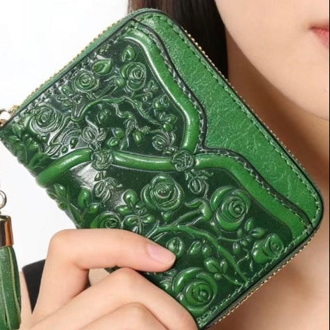 Green embossed wallet with tassel held by a person