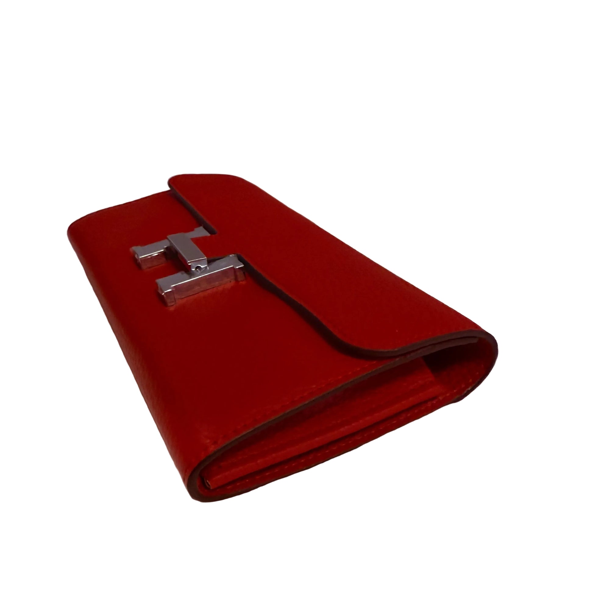 Red wallet with a silver logo on a white surface
