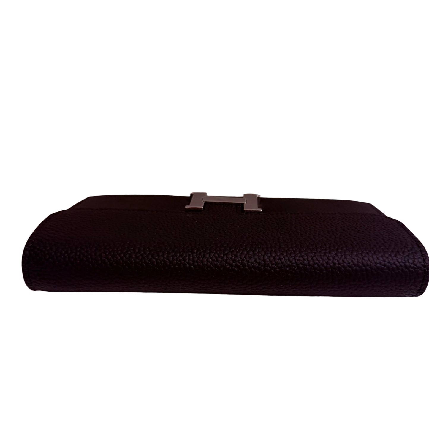 Black clutch bag with a silver clasp on a white surface against a light gray background