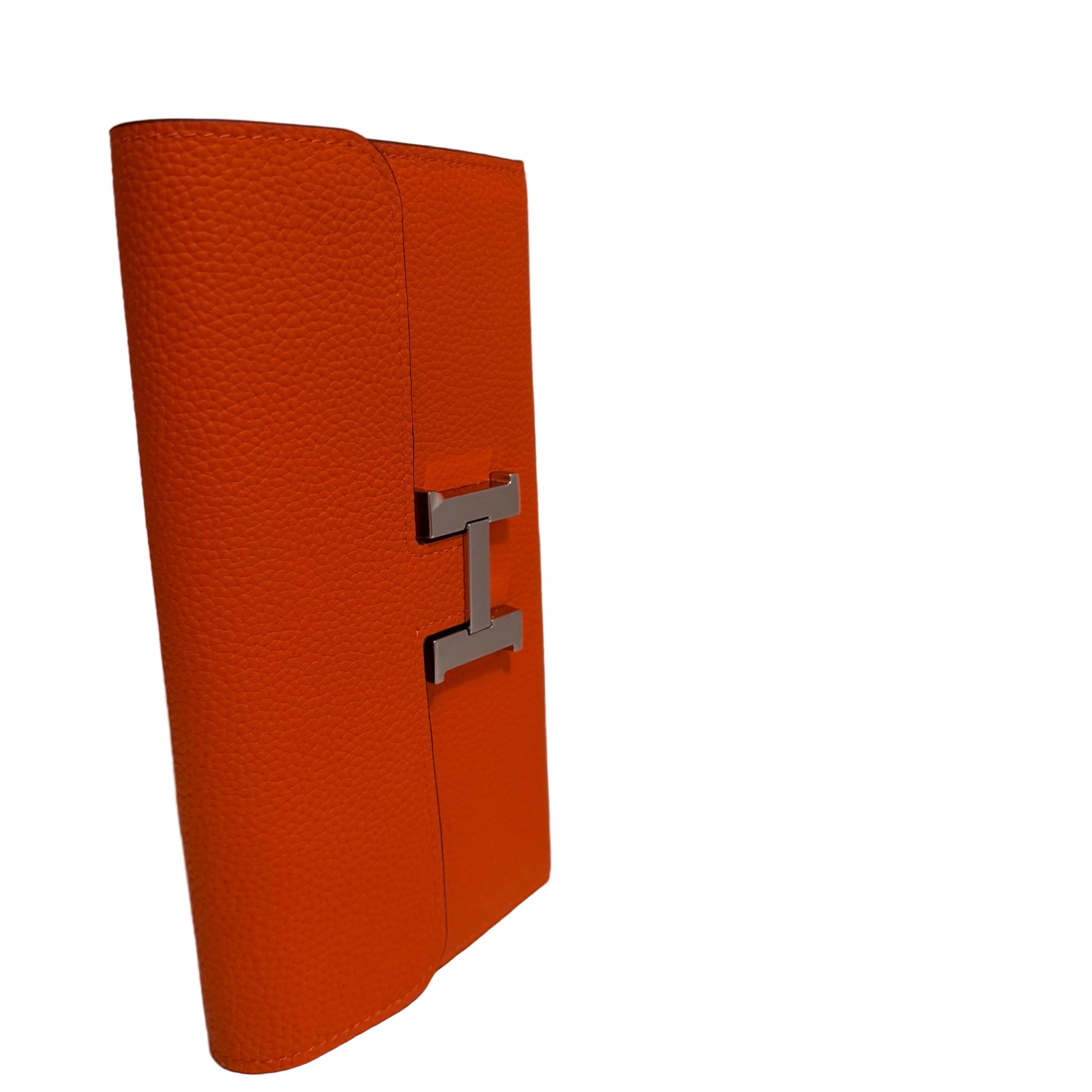 Orange textured wallet with a silver logo on a white surface and light gray background