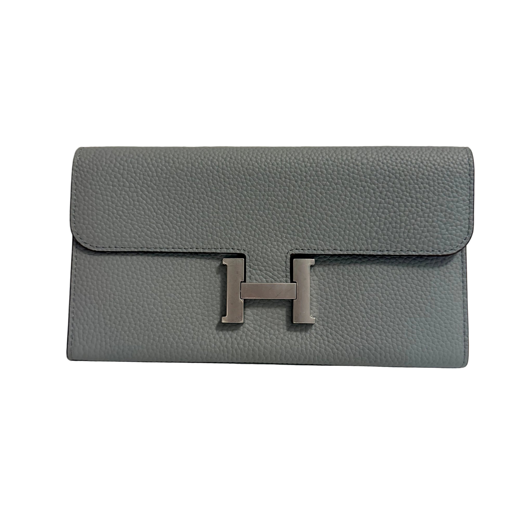 Gray clutch bag with a silver 'H' emblem on a light gray background