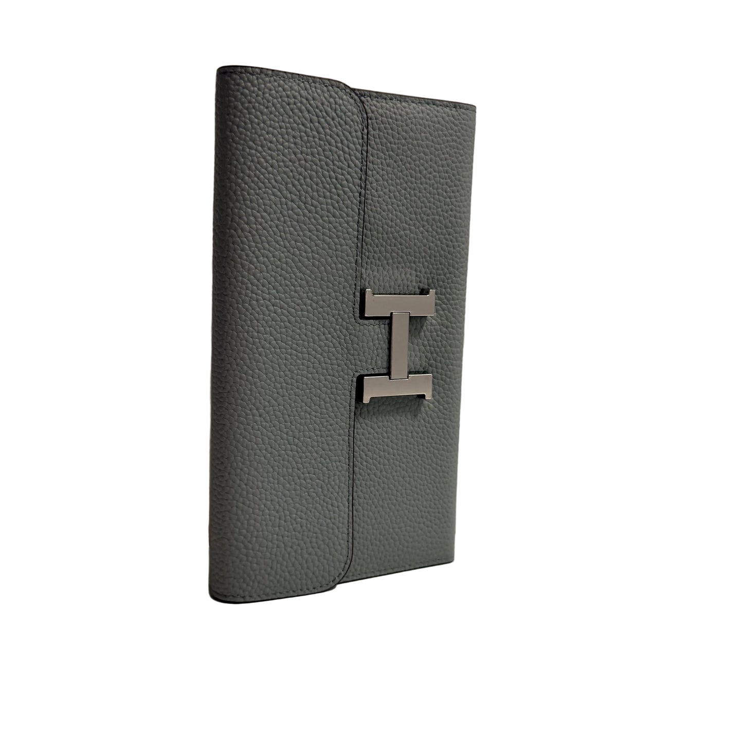 Gray leather wallet with a metal logo on a beige background