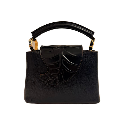 Black handbag with a decorative bow on a neutral background