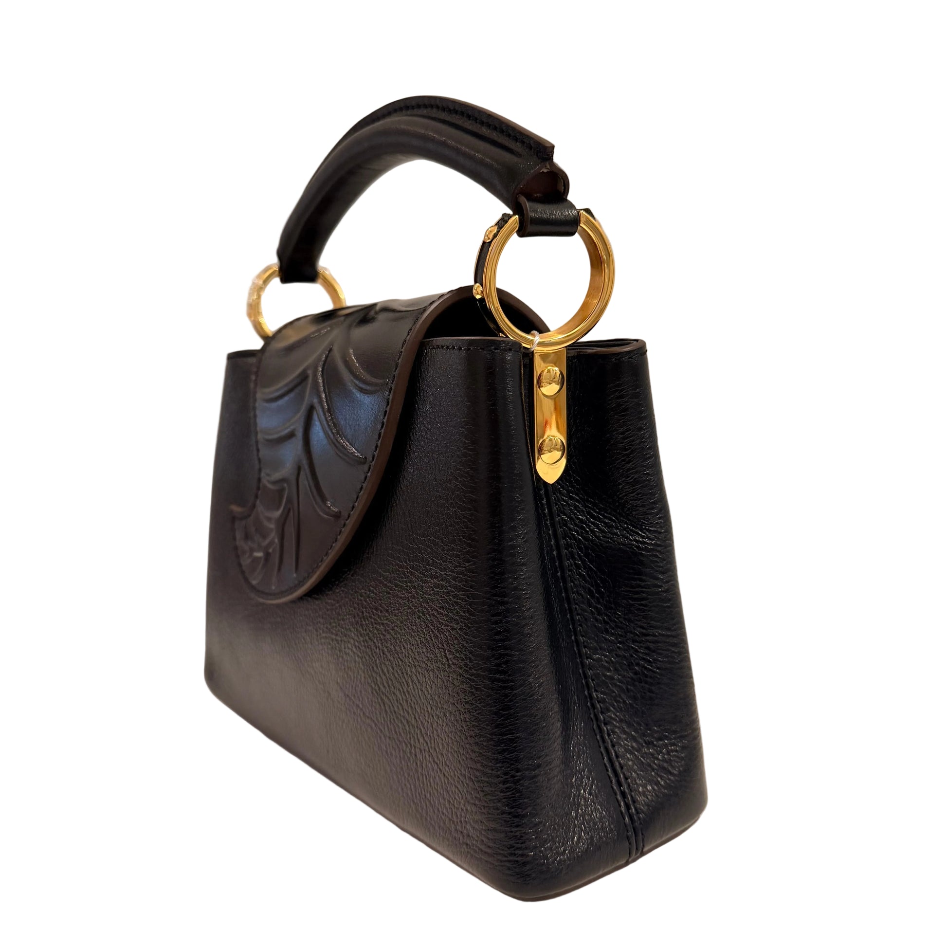 Black handbag with gold handle on a neutral background