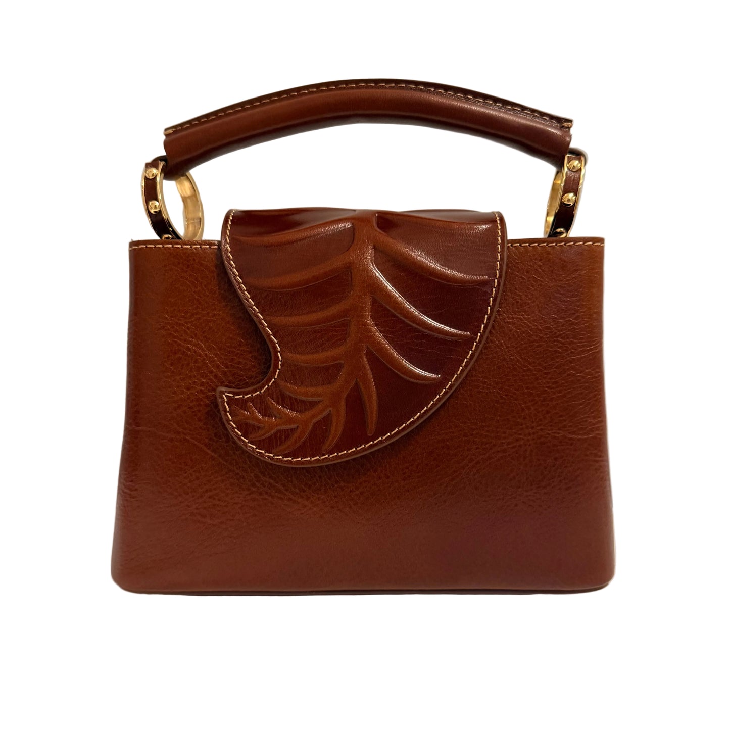 Brown handbag with leaf design on a white surface and light gray background