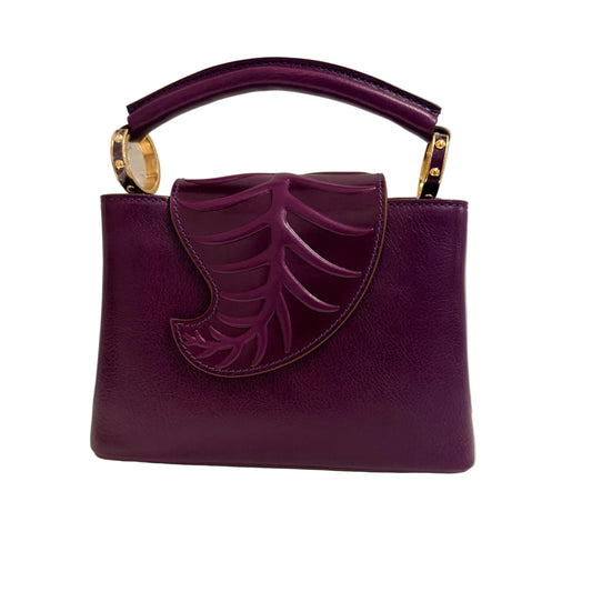 Purple handbag with leaf design on a neutral background