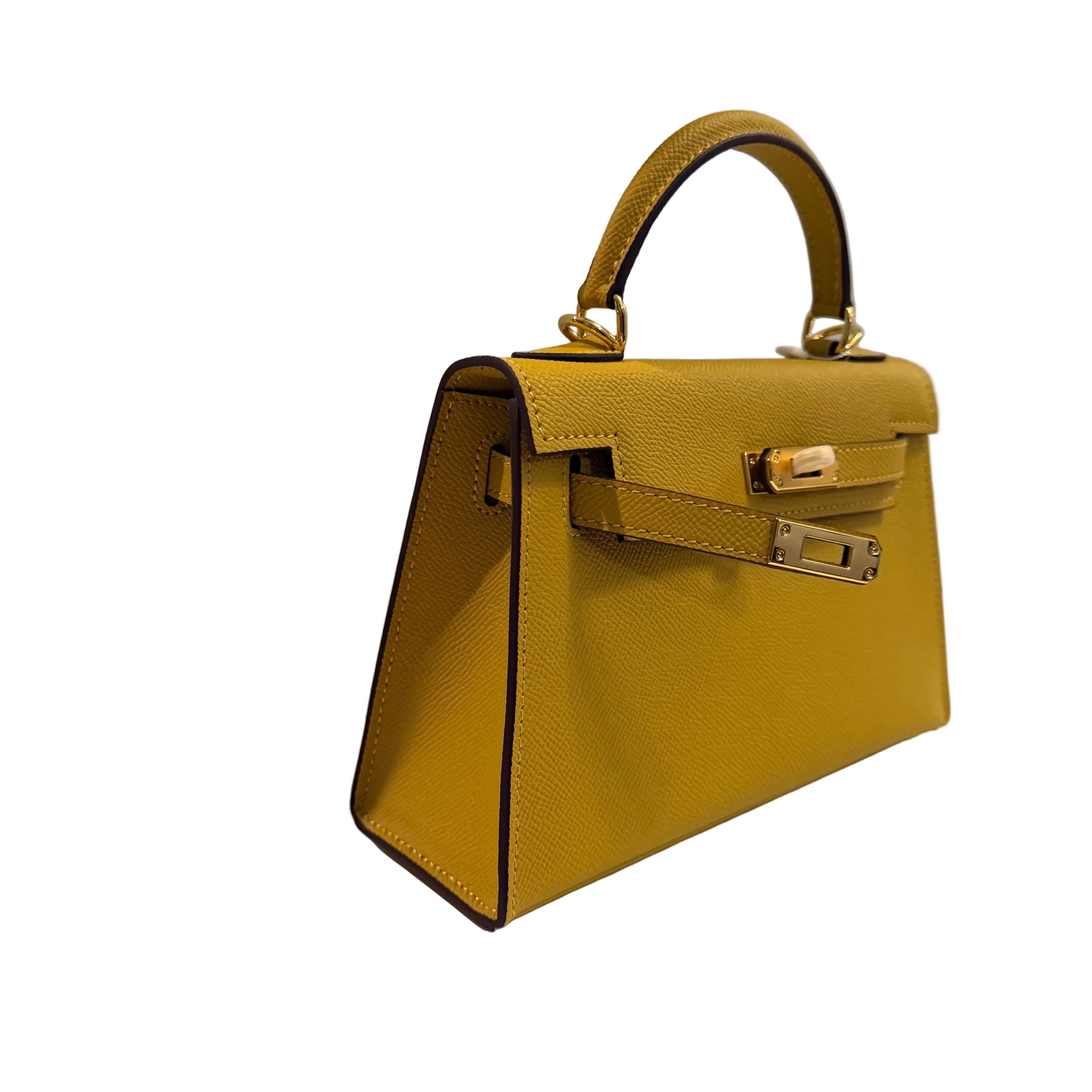 Yellow handbag with gold hardware on a light gray background