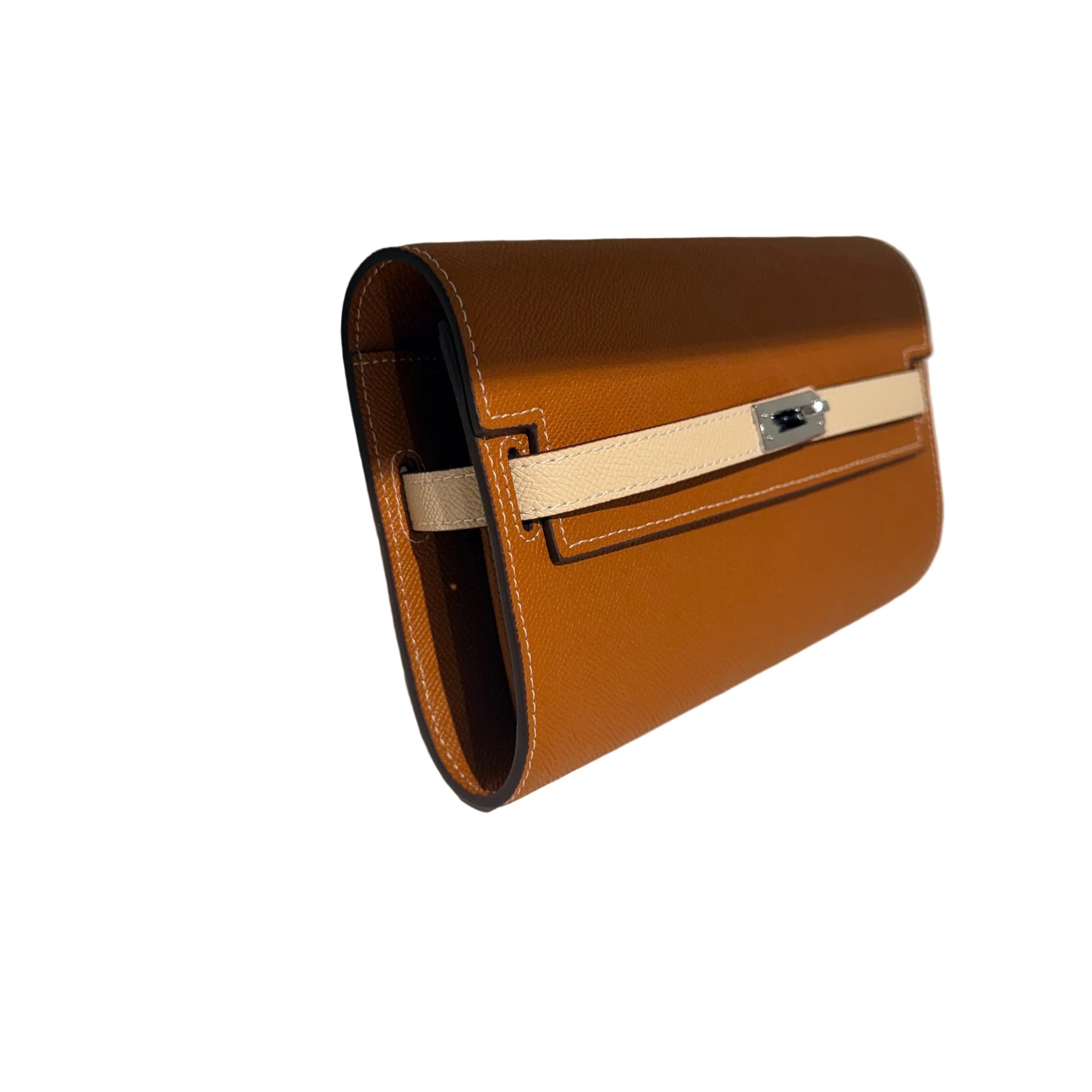 Brown leather handbag with a beige strap on a white surface