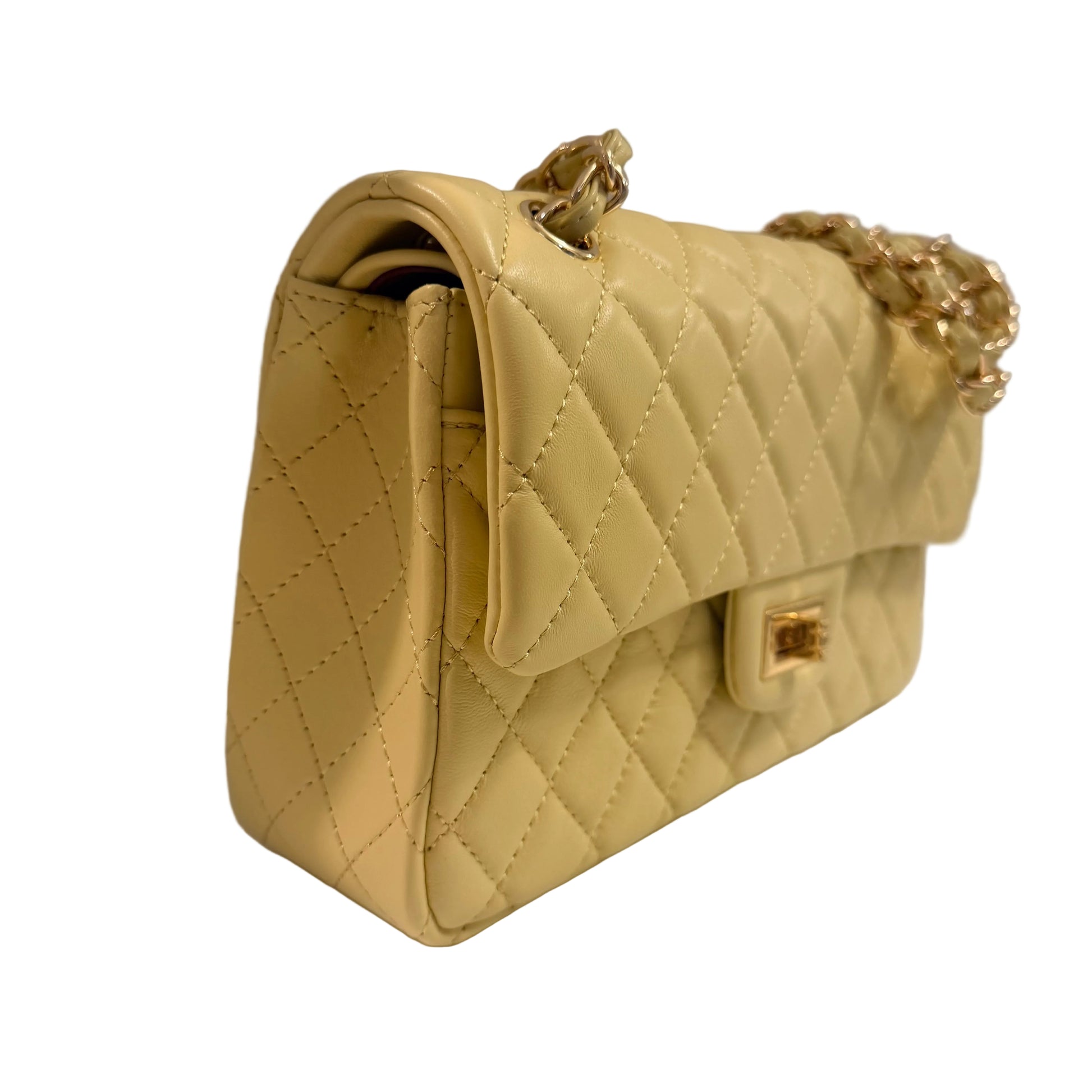 Beige quilted handbag with gold accents on a white surface