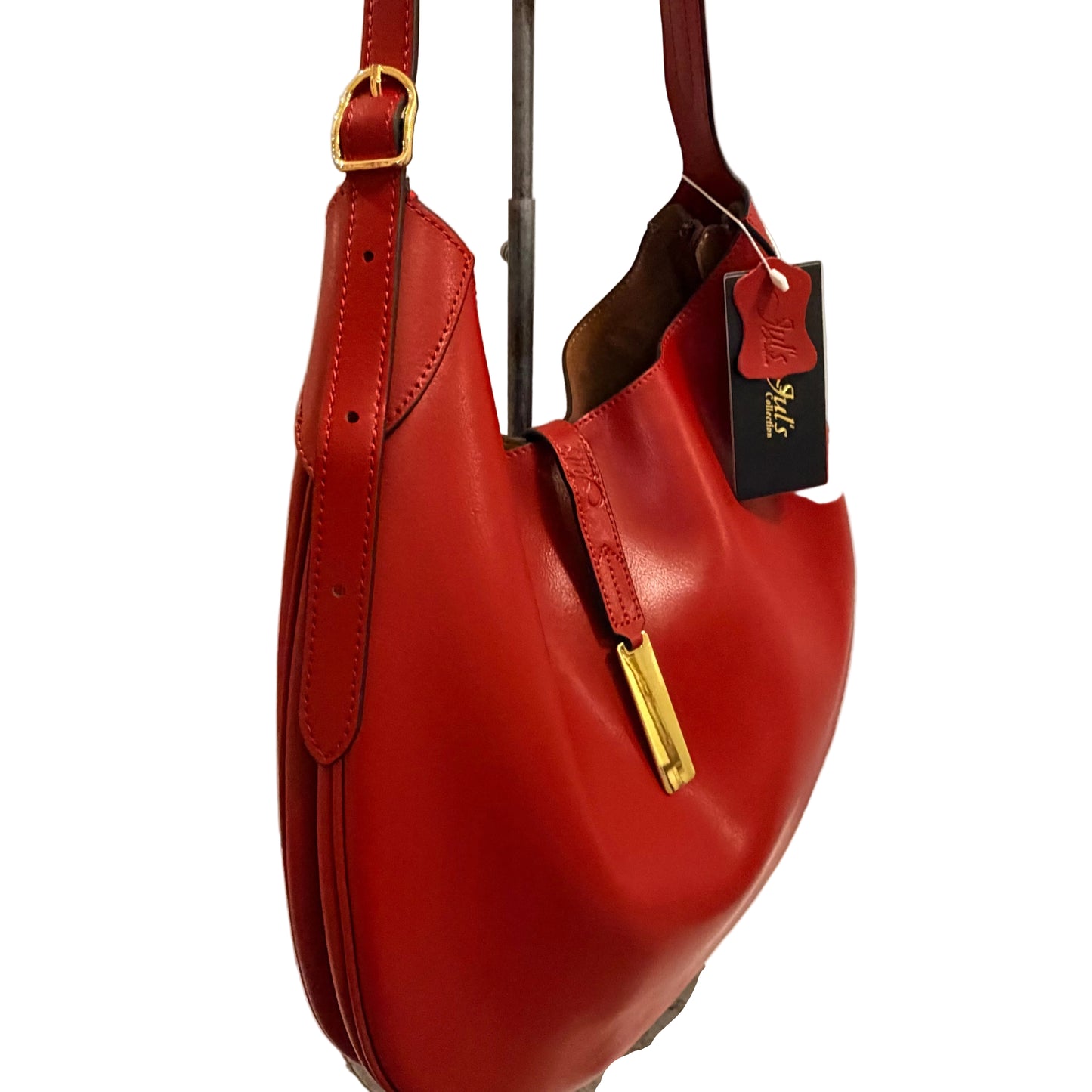 Red handbag with gold accents on a white surface against a light gray background