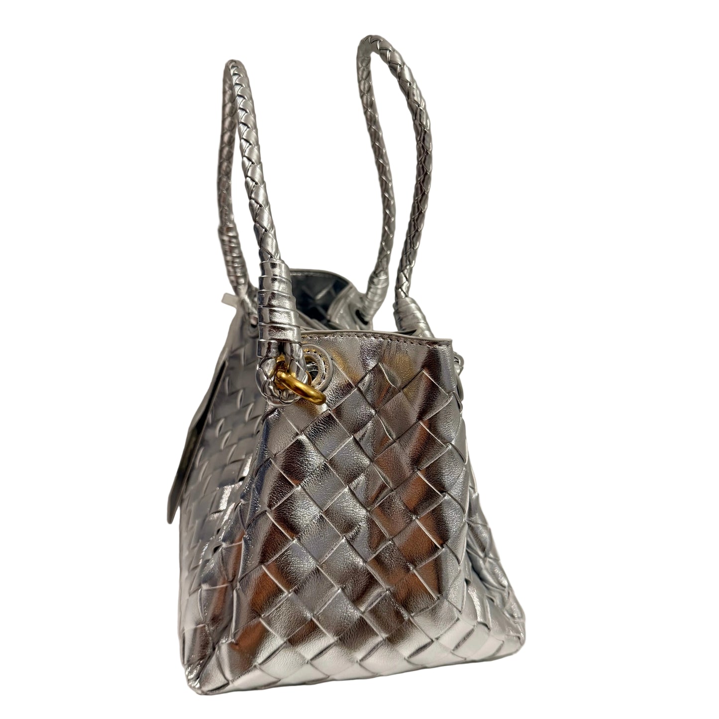 Silver woven handbag on a white surface with a neutral background