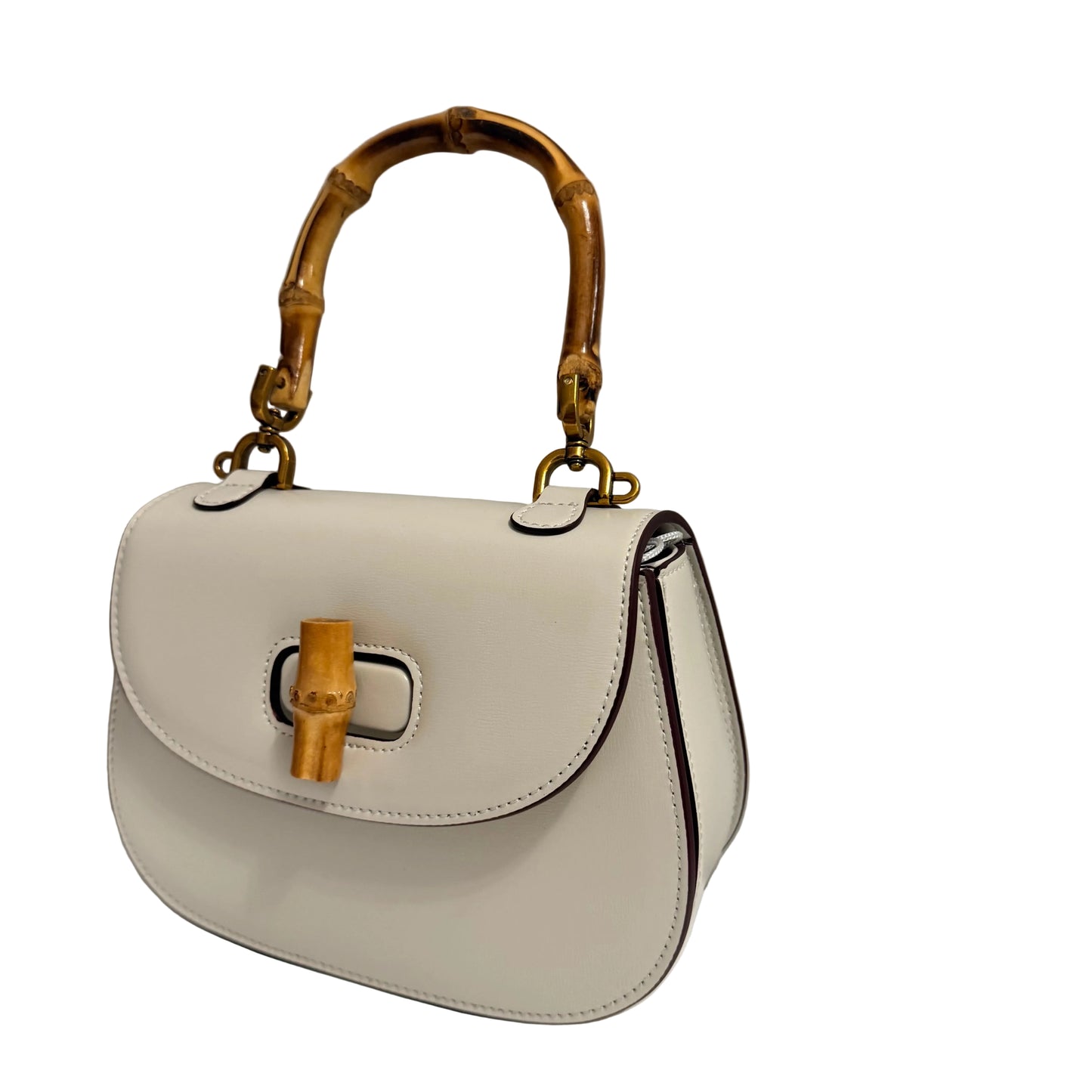 White handbag with bamboo handle and accents on a gray background