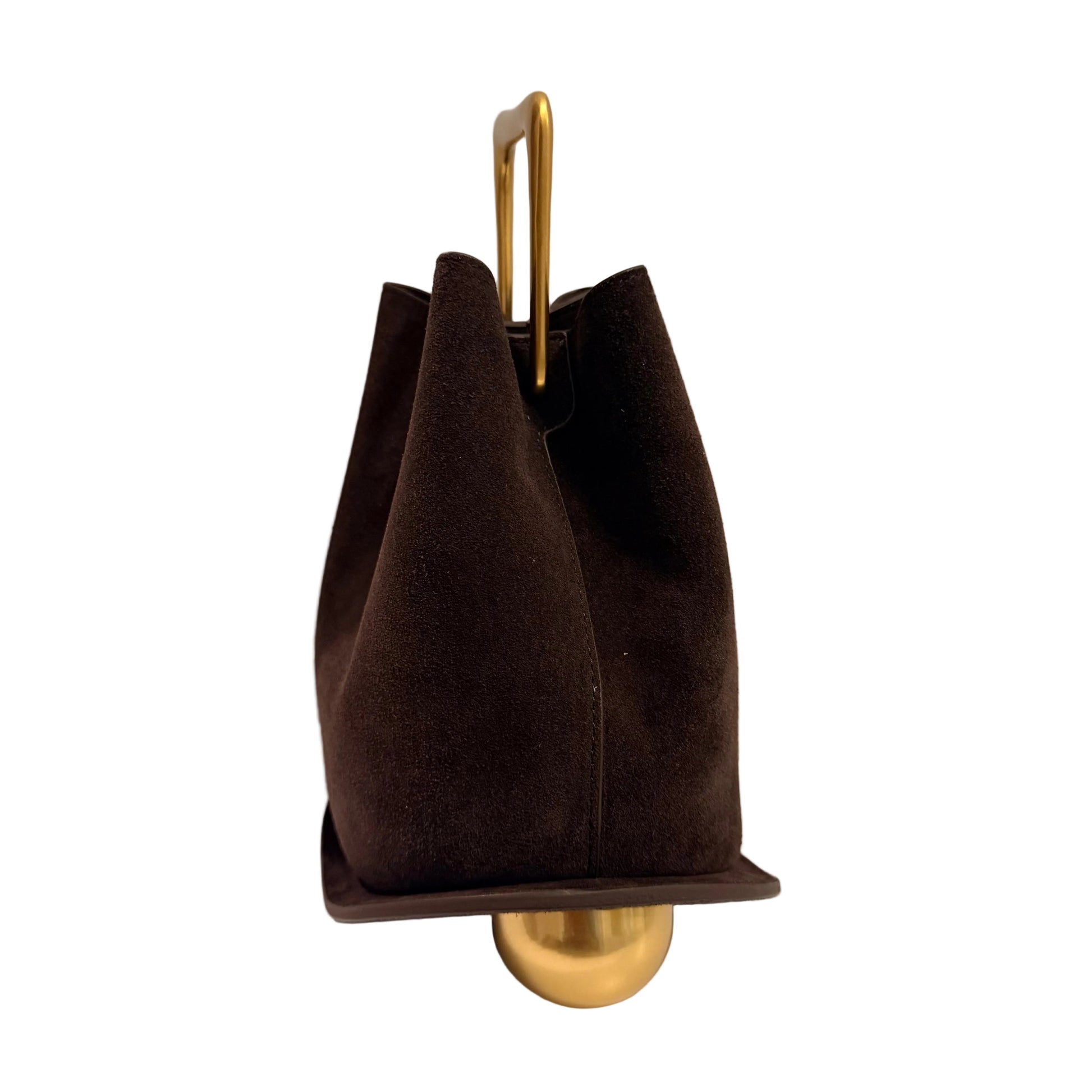 Brown handbag with gold handle and base on a white surface with gray background
