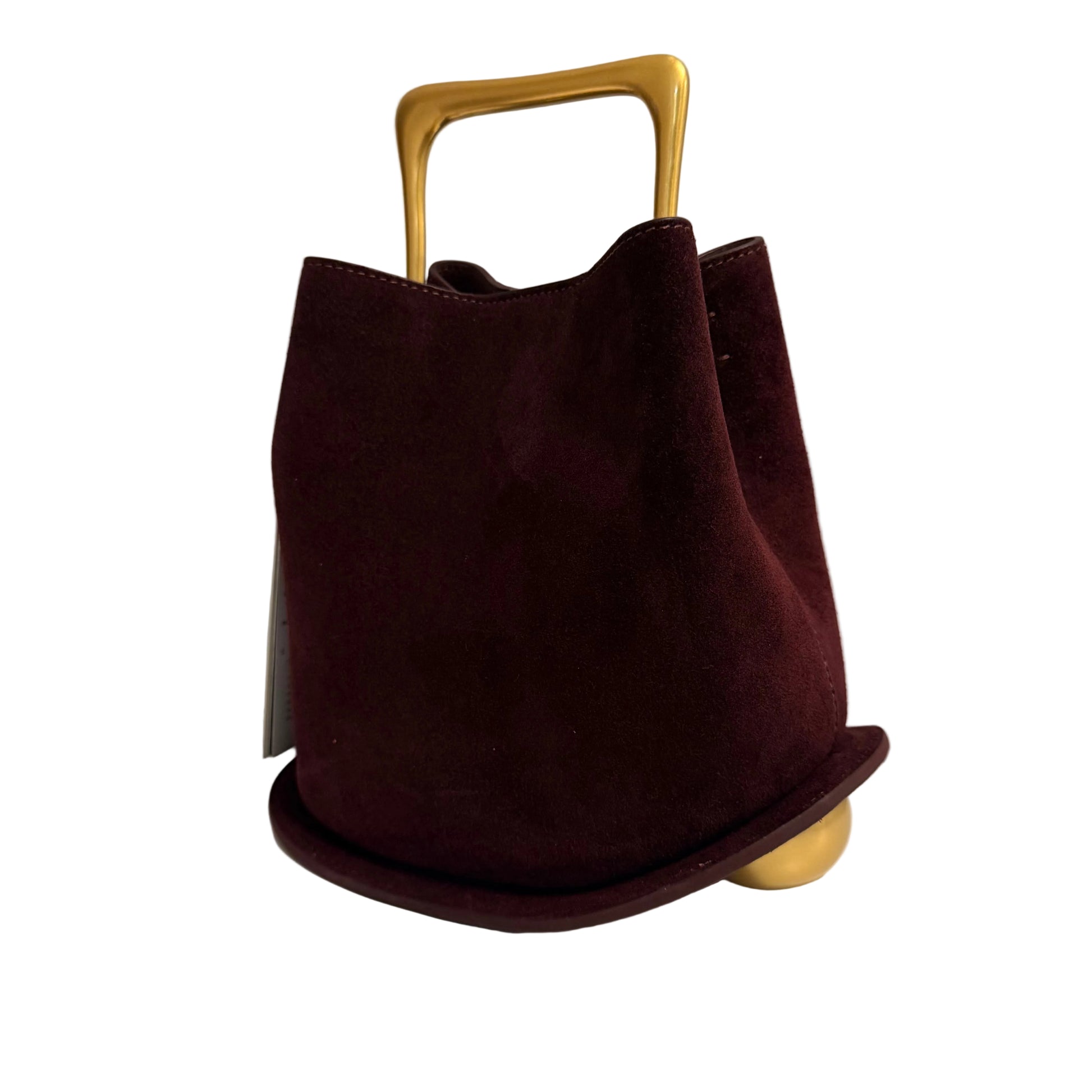 Brown handbag with a gold handle on a light surface