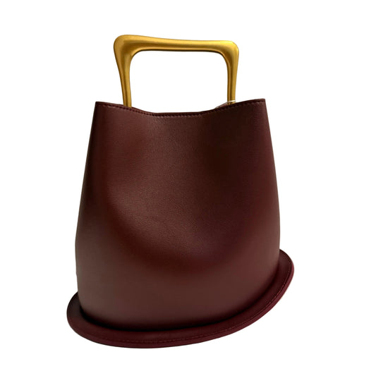 Brown handbag with a gold handle on a light gray background