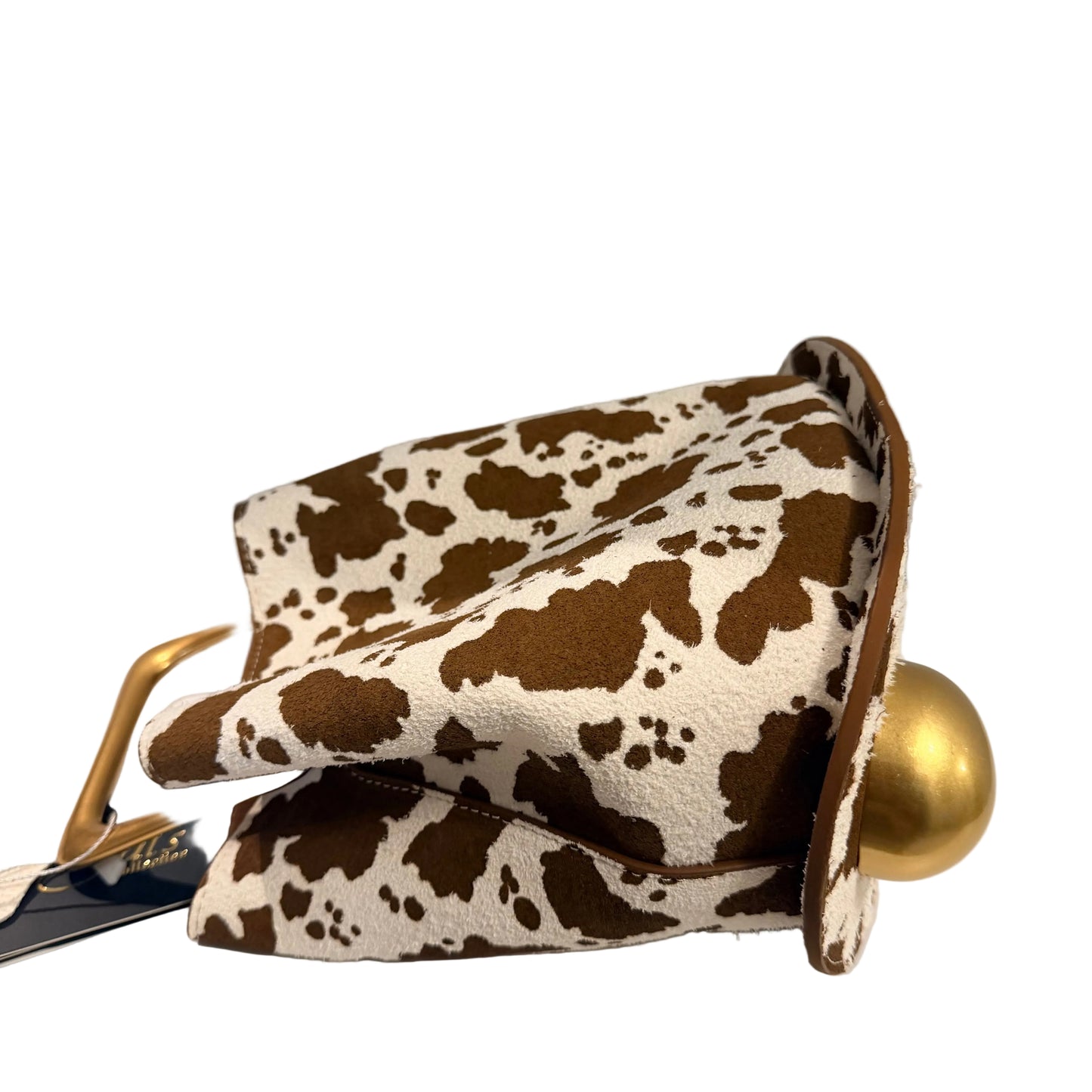 Cow print clutch bag with gold accents on a white surface