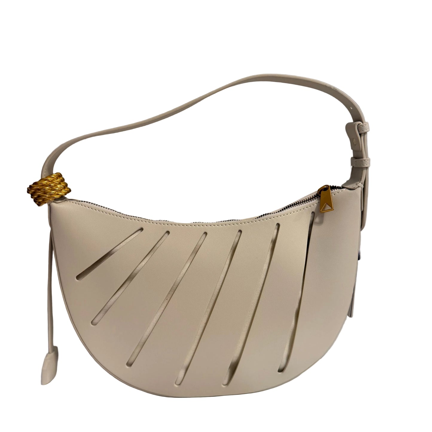 Beige handbag with cut-out design on a white surface and gray background