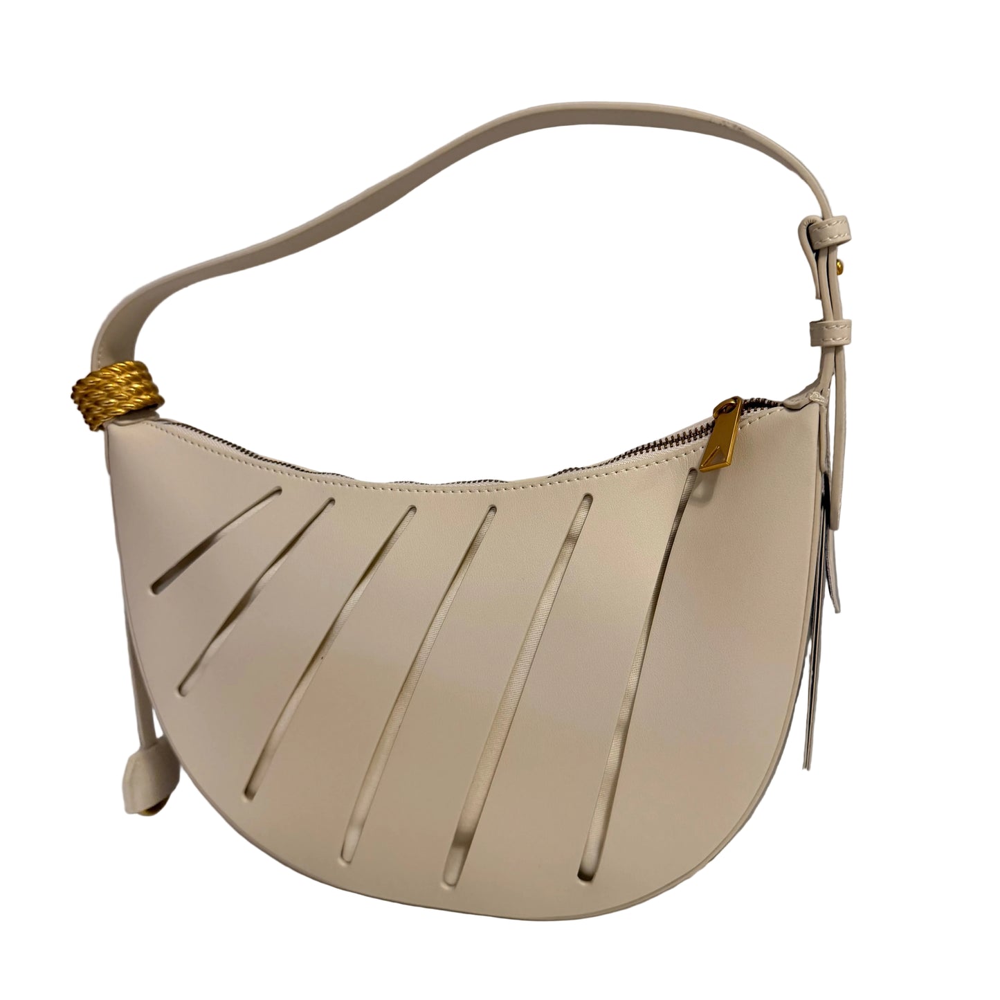 Beige handbag with gold accents on a white surface against a gray background
