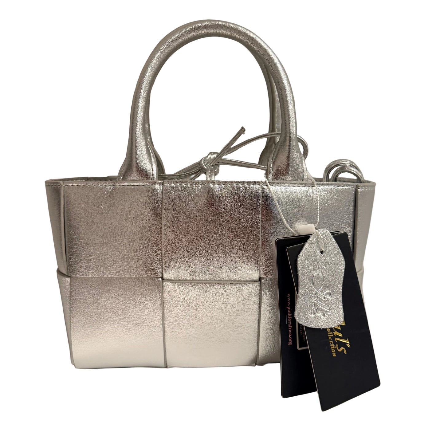 Silver handbag with a tag on a neutral background